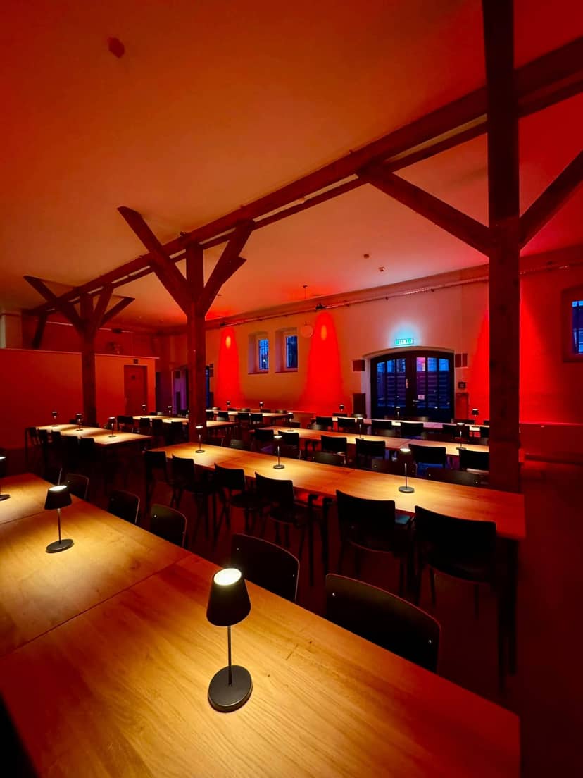 Modern event venue in Düsseldorf with timber frames and dynamic uplighting for workshops and dinners.