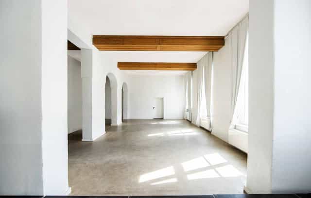 Modern corporate event venue in Düsseldorf with high ceilings, ideal for branding and workshops.