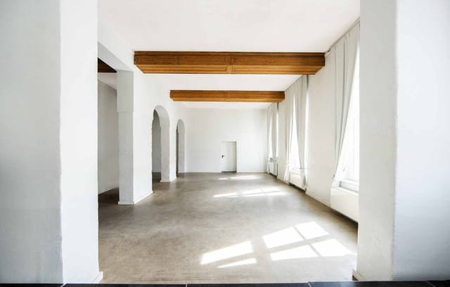Modern corporate event venue in Düsseldorf with high ceilings, ideal for branding and workshops.