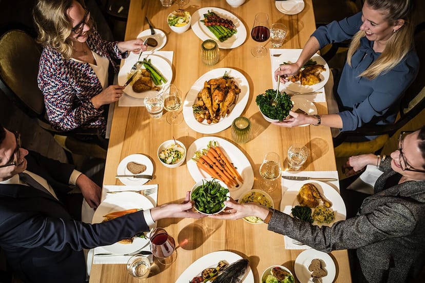 Show-Küche corporate networking dinner with family-style dining and elegant table settings.