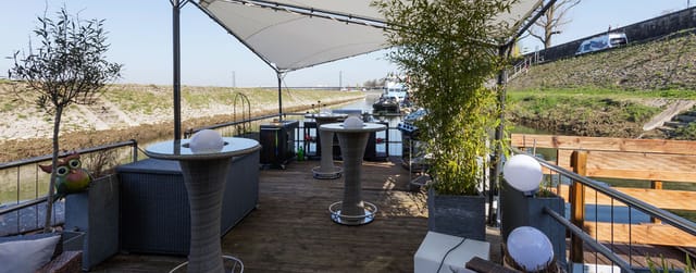Covered outdoor function deck at Fischers Kahn with cocktail tables for networking and receptions.