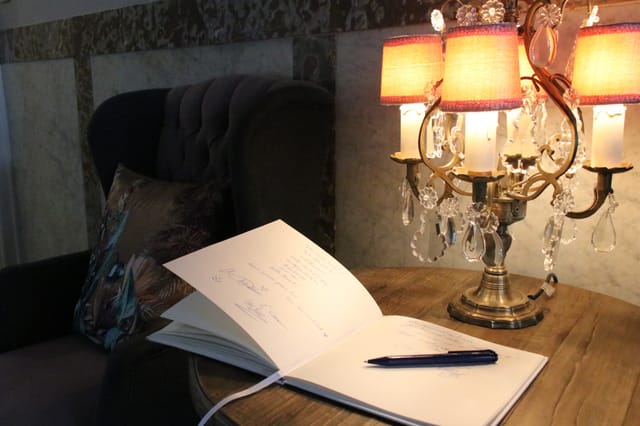 Upscale hotel library event foyer with classic guestbook station for corporate event registration.