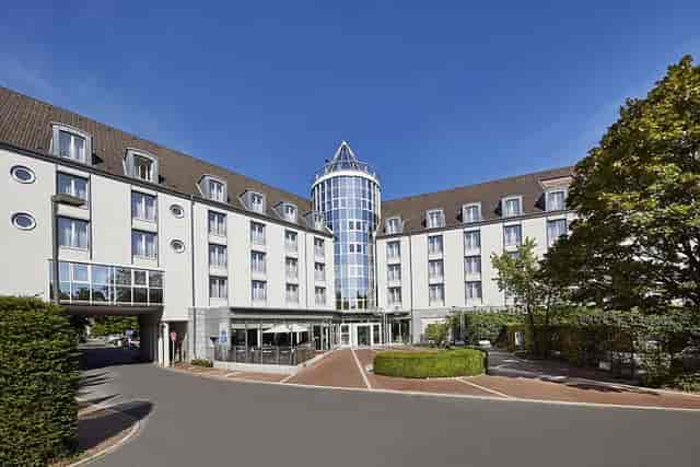 Lindner Hotel Dusseldorf Airport entrance with outdoor terrace for corporate retreats.