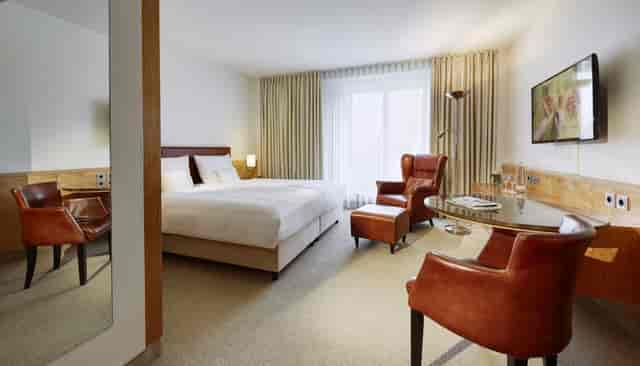 Upscale Lindner Hotel Dusseldorf guest room with workspace for corporate business travel.