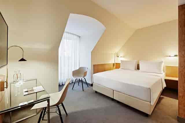 Modern Lindner Hotel Dusseldorf Airport room with king bed for business travel and conferences.