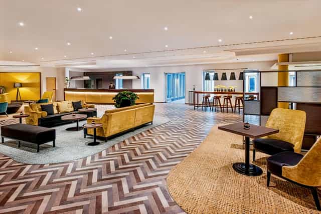 Modern Sheraton Düsseldorf Airport hotel lobby for business networking and corporate event breakout.