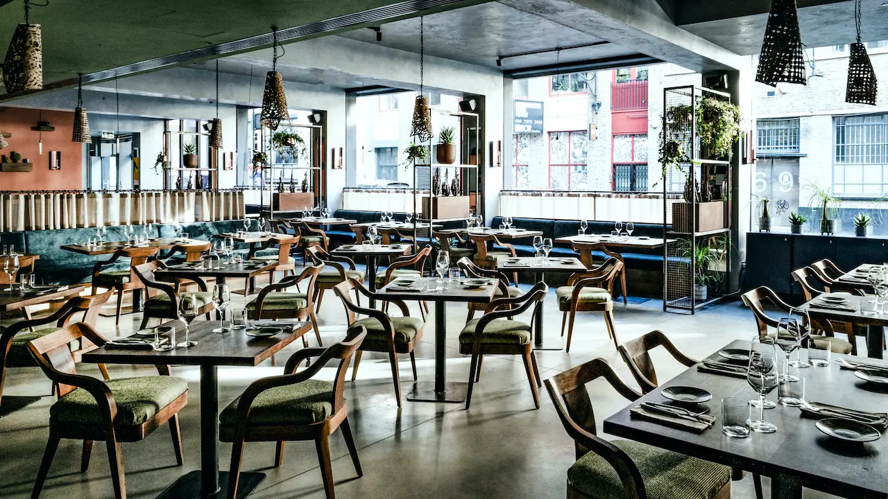 Industrial-chic restaurant venue for corporate dinners and networking events with natural light. - Banner