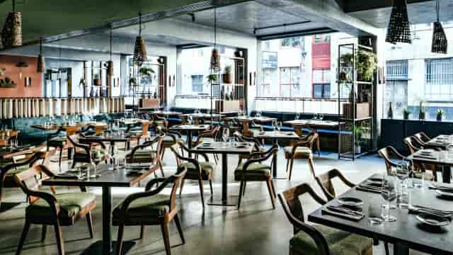 Industrial-chic restaurant venue for corporate dinners and networking events with natural light.