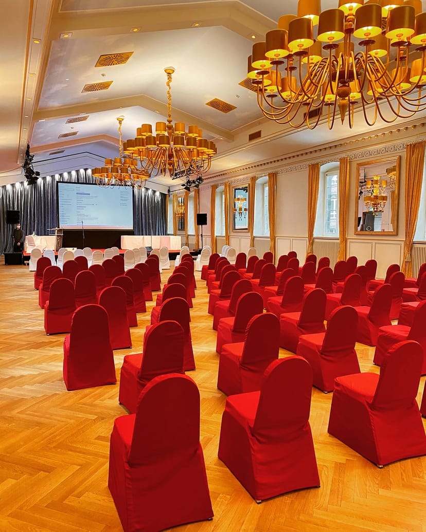 Wolkenburg ballroom with red theater seating for formal conferences and presentations.