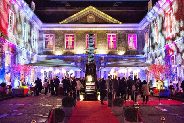 Wolkenburg inner courtyard evening reception with architectural projection mapping event.