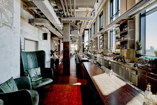 Industrial-chic hotel suite for VIP networking and cocktail reception events with skyline views.