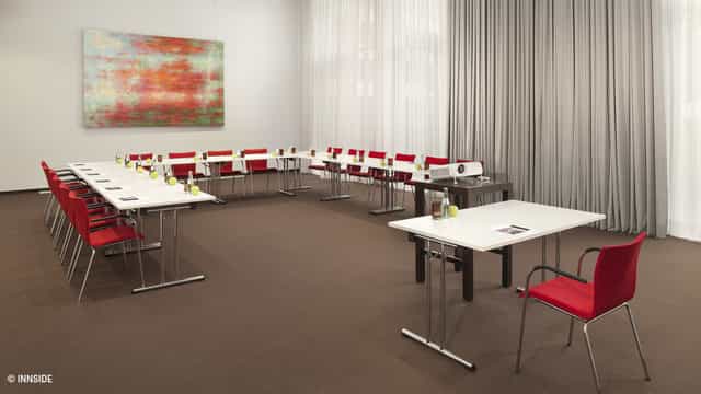 U-shaped conference room at INNSiDE Düsseldorf with modern art, perfect for business meetings.