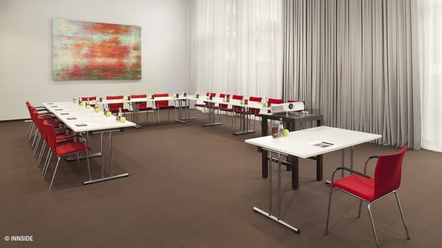 U-shaped conference room at INNSiDE Düsseldorf with modern art, perfect for business meetings.