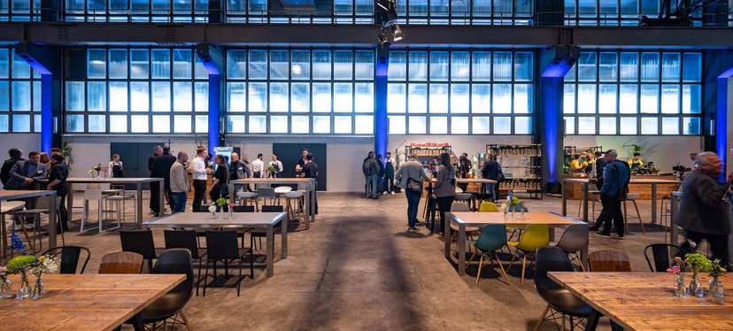Industrial warehouse event space with high ceilings for networking receptions and corporate mixers.