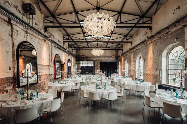Industrial chic venue with chandeliers for upscale weddings and corporate galas.