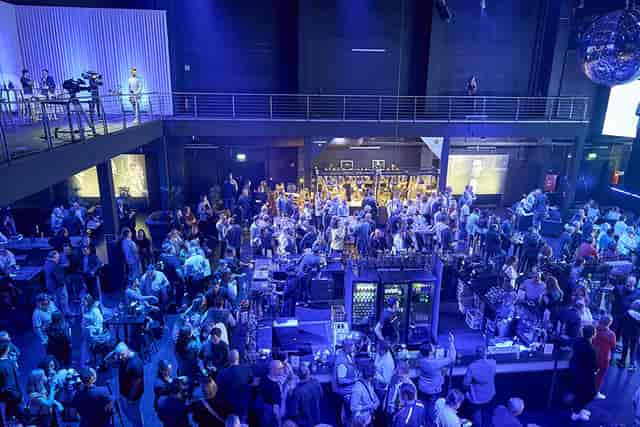 Multi-level soundstage event space with bar for corporate networking and evening receptions.