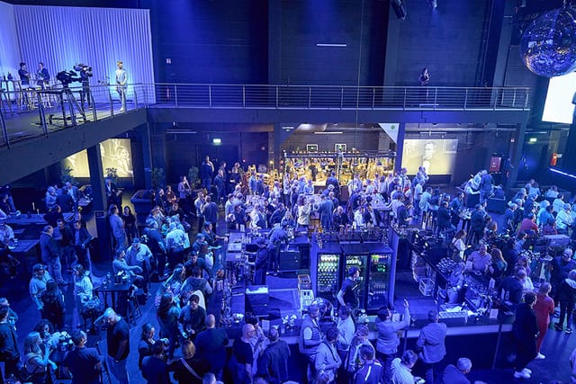 Multi-level soundstage event space with bar for corporate networking and evening receptions.