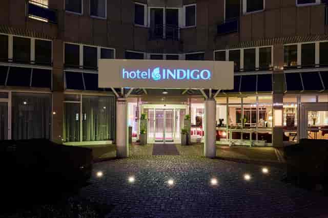 Hotel Indigo Dusseldorf exterior at night, perfect for intimate corporate retreats and events.