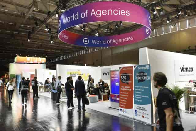 Koelnmesse Halle 8 trade show floor with circular signage at DMEXCO digital marketing conference.