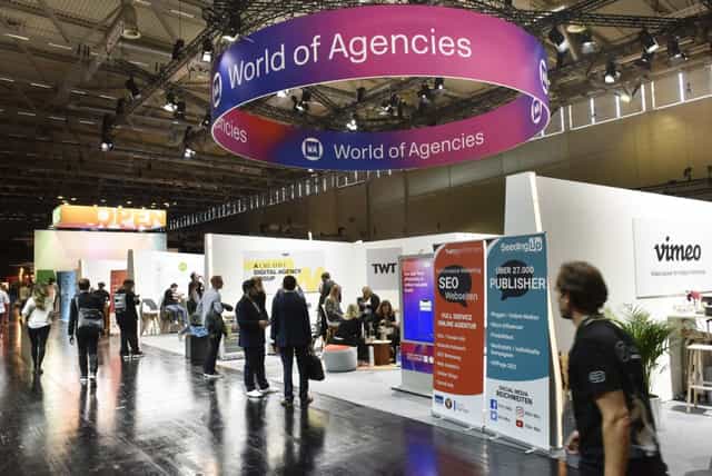 Koelnmesse Halle 8 trade show floor with circular signage at DMEXCO digital marketing conference.