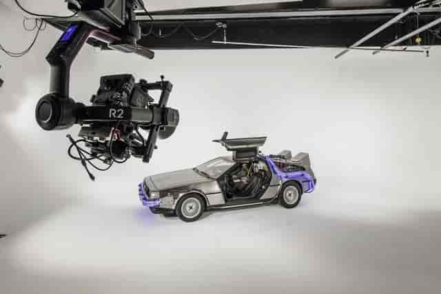 Futuristic event studio with DeLorean time machine for creative branding and live streaming.