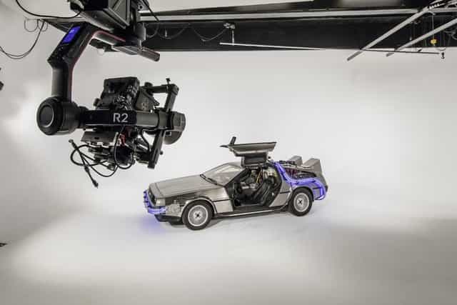 Futuristic event studio with DeLorean time machine for creative branding and live streaming.