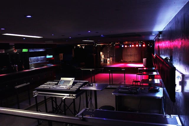 Small Luxor event venue with elevated stage and dynamic lighting for corporate showcases.
