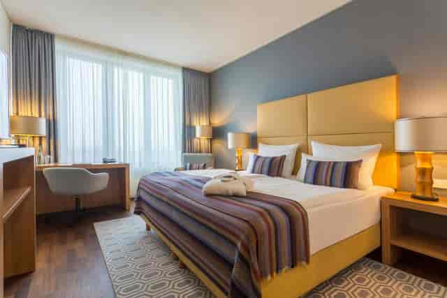 Modern hotel room at AMERON Köln Hotel Regent with workspace for corporate business events.