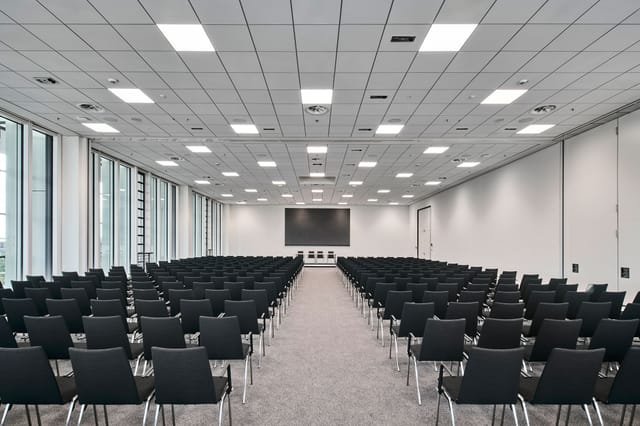 Theater-style conference center with natural light for corporate events and presentations.