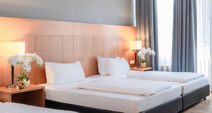Standard twin-bedded hotel room at PLAZA Premium Hotel Köln for corporate conference accommodation.