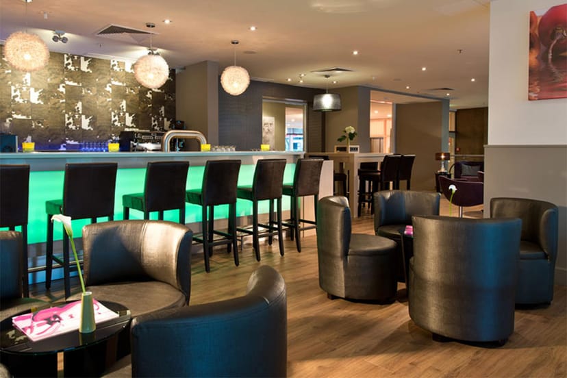 Modern hotel bar with LED counter for corporate networking and business cocktail events.