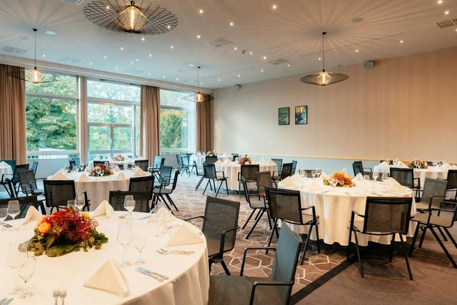 Banquet hall at Leonardo Royal Hotel Köln with floral centerpieces for formal event venue rental.