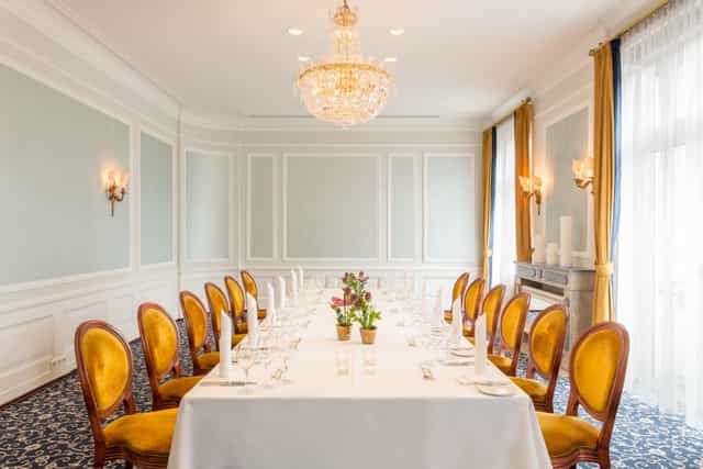 Elegant boardroom at Excelsior Hotel Ernst with gold velvet chairs, ideal for executive meetings.
