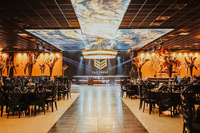 Ballroom with backlit ceiling and stage lighting for corporate gala and awards event.