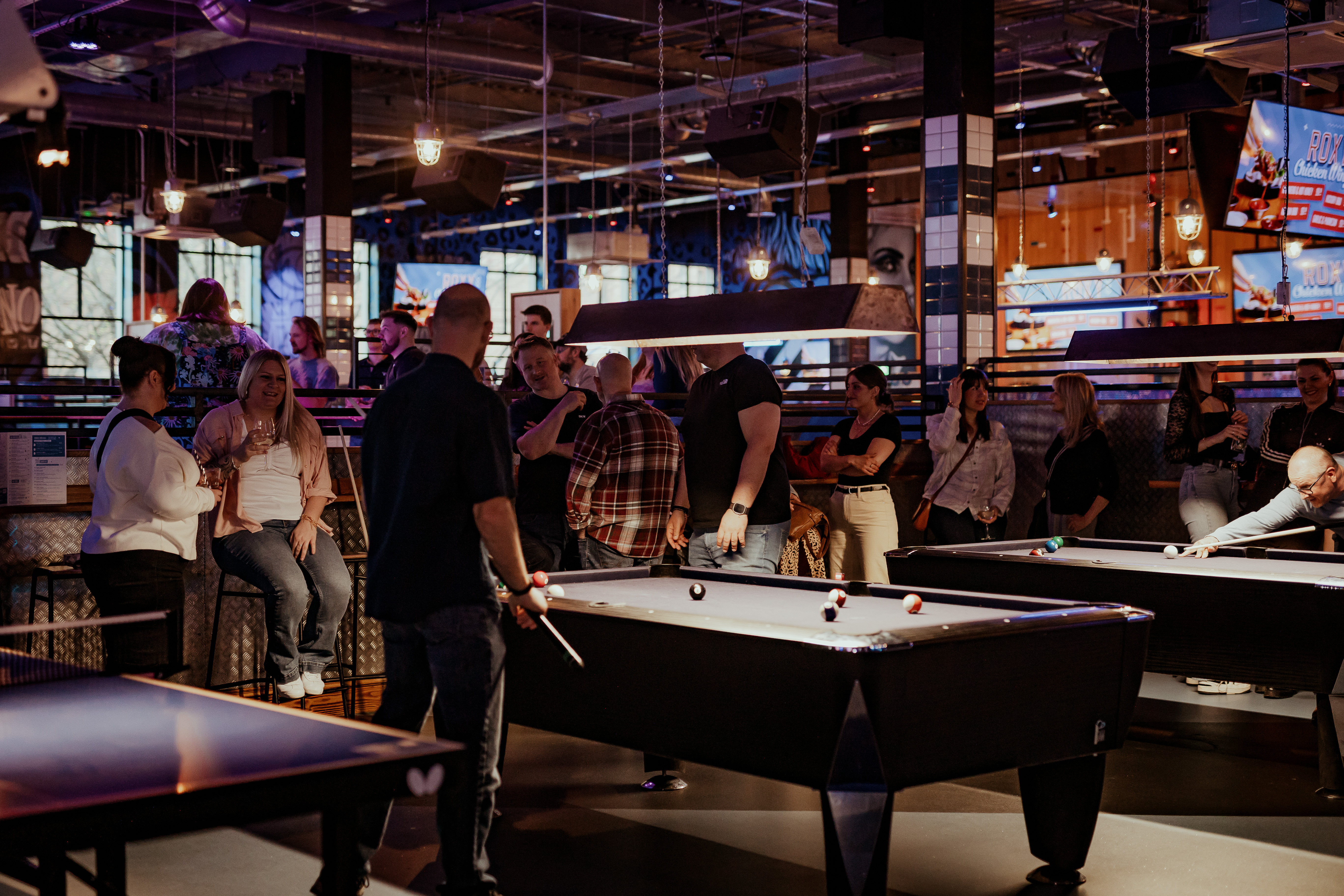 Vibrant social event at Roxy Lanes with pool tables, ideal for networking and celebrations.