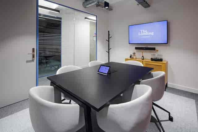 Modern conference room with black table, ideal for meetings and presentations.