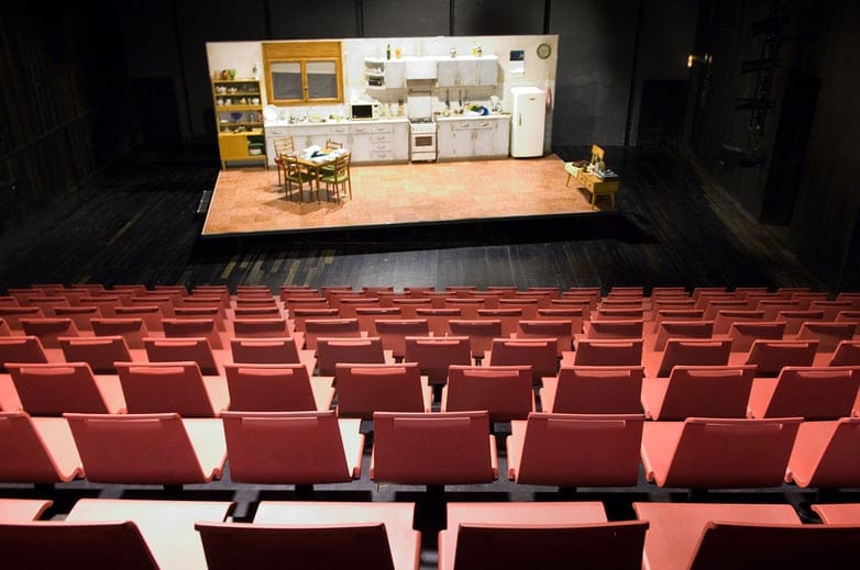 Proscenium theater auditorium with kitchen stage set for corporate conference or seminar.