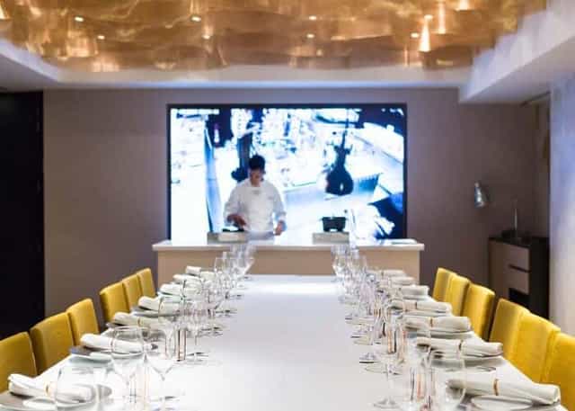 Private dining at Caelis with integrated AV wall for corporate events and chef demonstrations.