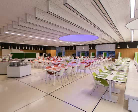 Modern corporate event space with modular tables, ideal for networking and business catering.