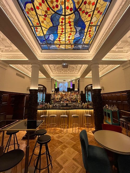 Upscale cocktail bar in Barcelona with ornate ceiling for networking and corporate events.