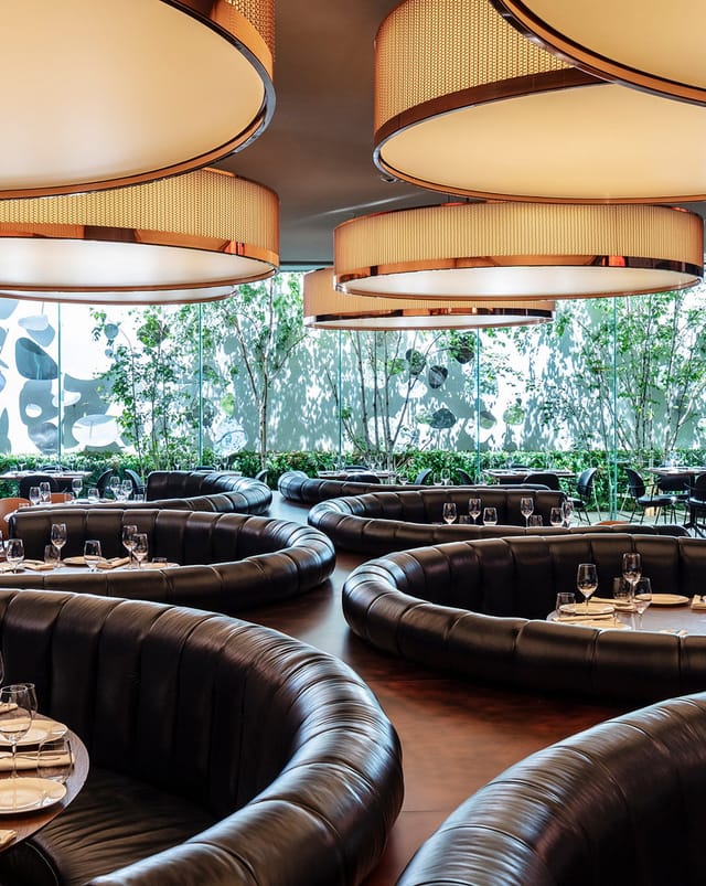 Modern Sir Victor Hotel restaurant with circular booths for VIP corporate dining and networking.