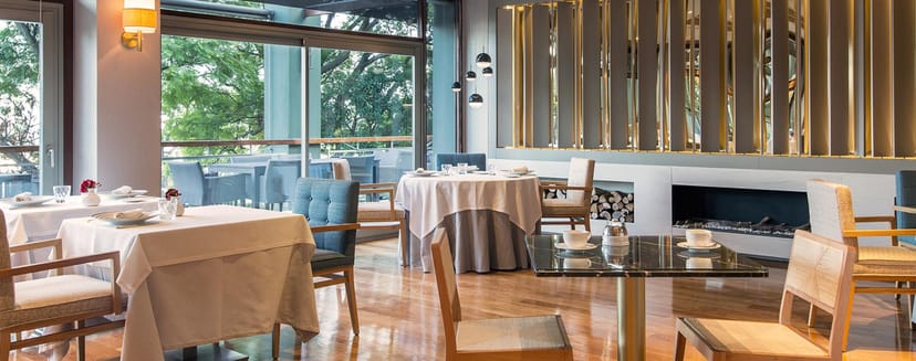 Executive lunch restaurant at Hotel Miramar Barcelona with sophisticated indoor-outdoor design.
