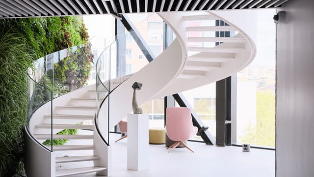 Modern breakout space with dramatic staircase for VIP networking and influencer events.