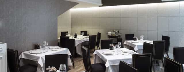 Upscale square dining tables for business dinners in a professional Catalonia restaurant setting.