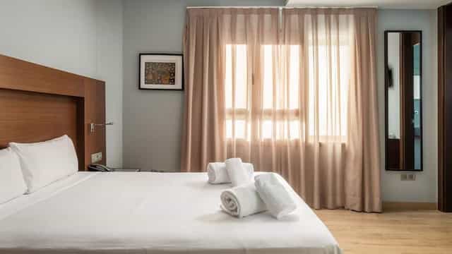 Hotel Madanis room for conference attendees: clean, functional design with neutral tones.