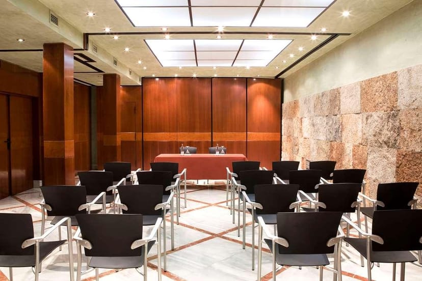 Boardroom-style Sala Garden with wood and stone; ideal for corporate meetings and workshops.