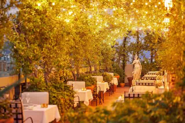 Rooftop garden event venue with bistro lighting, ideal for romantic wedding receptions.