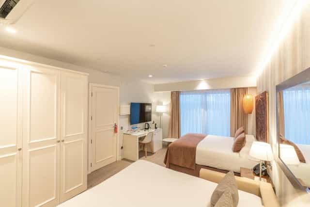 Triple room in Serennia Fira Gran Via with workspace, ideal for business travel and conferences.
