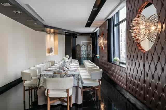 Elegant event space with a long dining table, ideal for corporate meetings and gatherings.