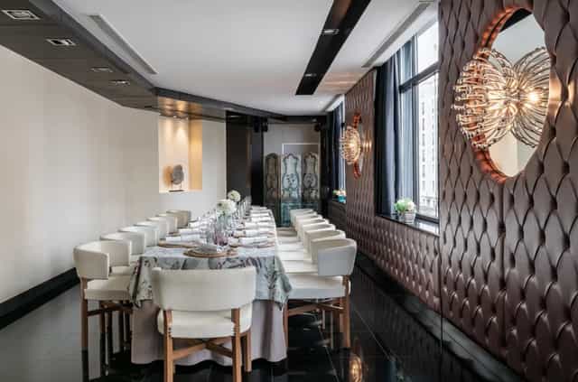 Elegant event space with a long dining table, ideal for corporate meetings and gatherings.